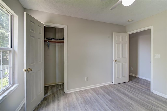610 SE Joel Ave, Lees Summit, MO 64063 - unfurnished bedroom with wood finished floors, a closet, a textured ceiling, and ceiling fan