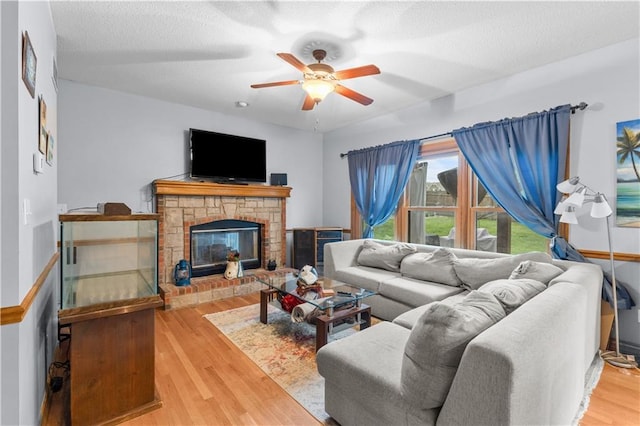 4022 SW Flintrock Dr, Lees Summit, MO 64082 - living room with ceiling fan, wood finished floors, a glass covered fireplace, and a textured ceiling