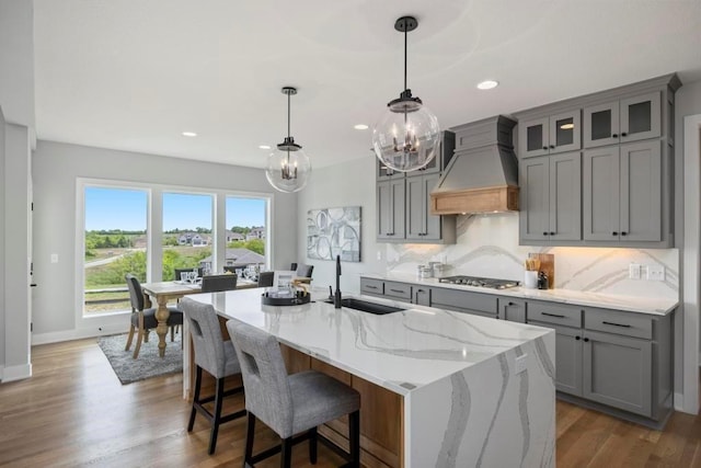 22112 W 80th Ter, Shawnee, KS 66220 - kitchen with gray cabinetry, premium range hood, a sink, a chandelier, and decorative backsplash