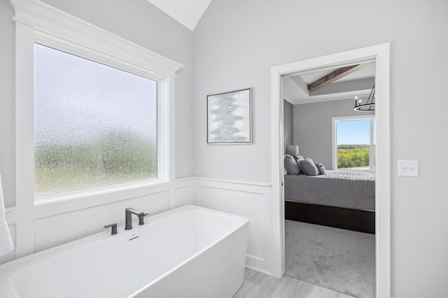 22112 W 80th Ter, Shawnee, KS 66220 - ensuite bathroom featuring a soaking tub, a chandelier, wainscoting, and lofted ceiling