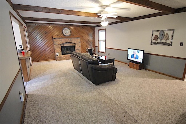 515 Mulberry St, Lees Summit, MO 64086 - carpeted living room with beam ceiling, ceiling fan, wood walls, a fireplace, and baseboards