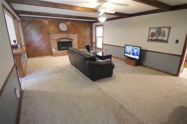 515 Mulberry St, Lees Summit, MO 64086 - carpeted living area featuring beam ceiling, a brick fireplace, wooden walls, a ceiling fan, and baseboards