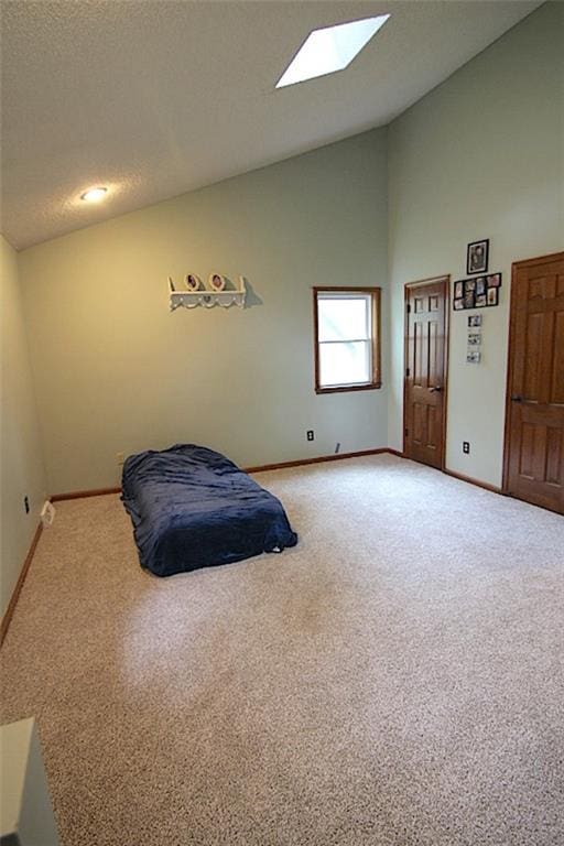 515 Mulberry St, Lees Summit, MO 64086 - carpeted bedroom with baseboards, a skylight, and high vaulted ceiling