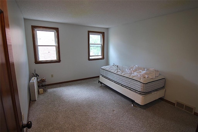 515 Mulberry St, Lees Summit, MO 64086 - carpeted bedroom featuring multiple windows, a textured ceiling, and baseboards