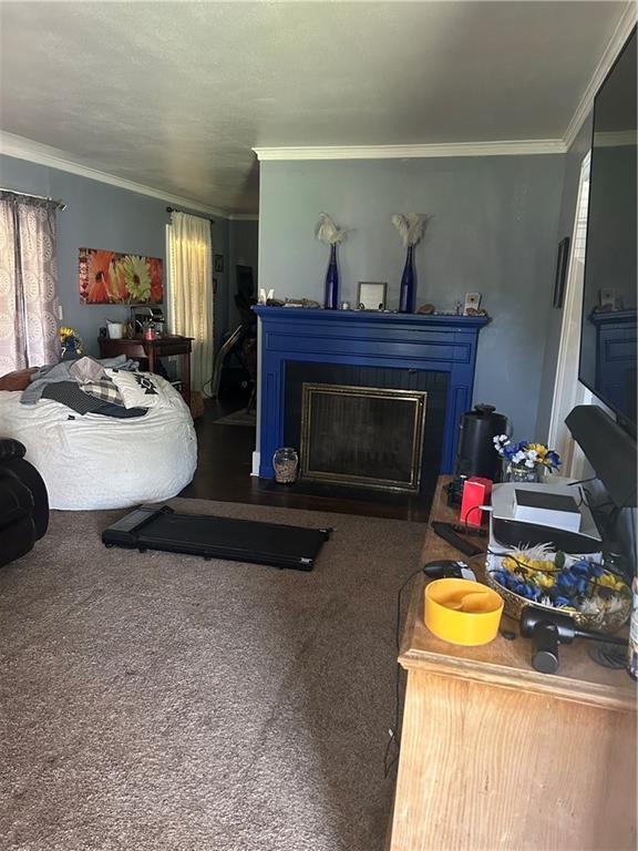 112 W Neosho St, Iola, KS 66749 - carpeted living room featuring ornamental molding and a fireplace