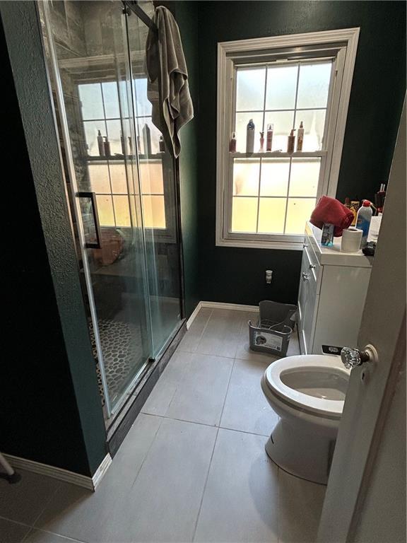 112 W Neosho St, Iola, KS 66749 - full bathroom with tile patterned floors, a stall shower, and toilet