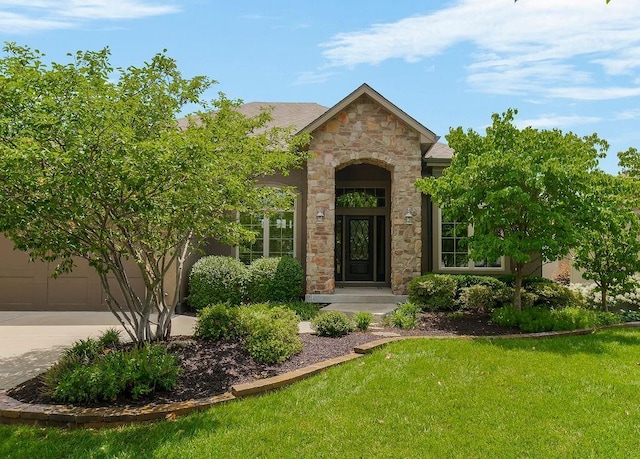 24793 W 98th St, Lenexa, KS 66227 - property entrance featuring stone siding, a lawn, concrete driveway, and an attached garage