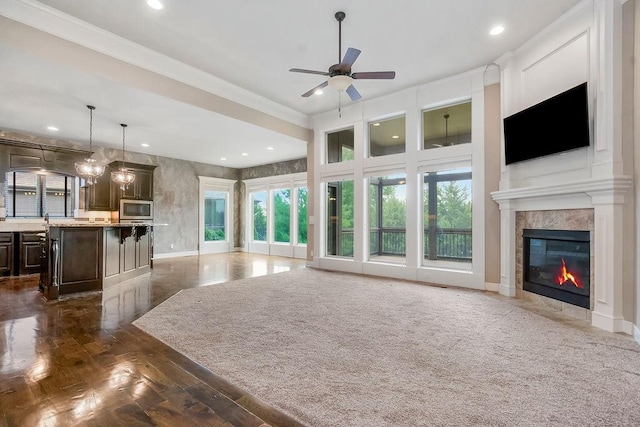 24793 W 98th St, Lenexa, KS 66227 - unfurnished living room with plenty of natural light, a tiled fireplace, ceiling fan, recessed lighting, and crown molding