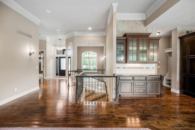 24793 W 98th St, Lenexa, KS 66227 - entryway featuring a chandelier, crown molding, dark wood finished floors, arched walkways, and recessed lighting