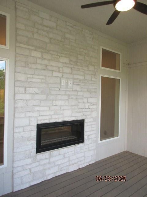 7031 N London Ave, Kansas City, MO 64151 - detailed view of a stone fireplace and ceiling fan