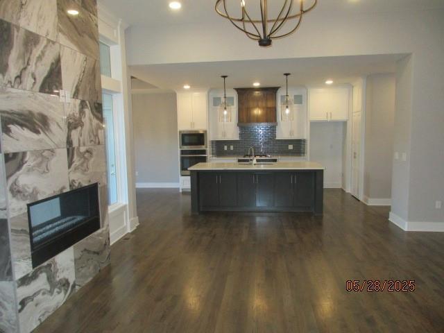 7031 N London Ave, Kansas City, MO 64151 - kitchen featuring light countertops, dark wood-type flooring, baseboards, white cabinetry, and recessed lighting