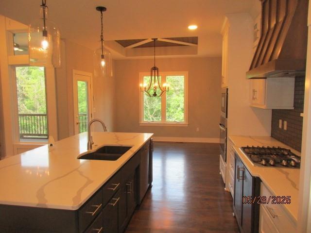 7031 N London Ave, Kansas City, MO 64151 - kitchen with a sink, appliances with stainless steel finishes, wall chimney exhaust hood, healthy amount of natural light, and recessed lighting