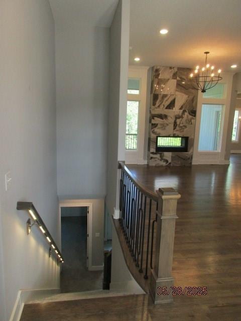7031 N London Ave, Kansas City, MO 64151 - stairway with a large fireplace, wood finished floors, a chandelier, baseboards, and recessed lighting