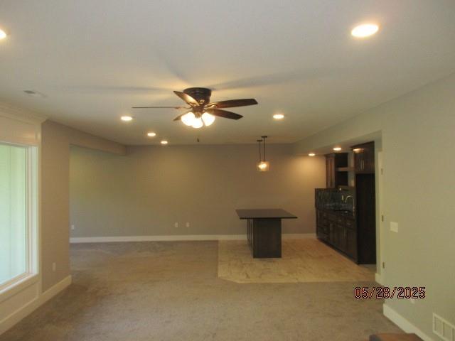 7031 N London Ave, Kansas City, MO 64151 - unfurnished living room featuring light colored carpet, recessed lighting, a ceiling fan, and baseboards