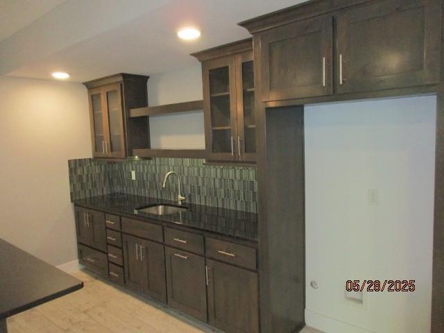 7031 N London Ave, Kansas City, MO 64151 - kitchen featuring open shelves, a sink, decorative backsplash, dark stone counters, and dark brown cabinets