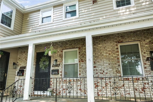 6773 N Askew Cir, Gladstone, MO 64119 - entrance to property featuring a porch and brick siding