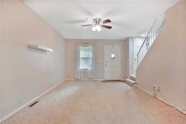 6773 N Askew Cir, Gladstone, MO 64119 - entryway featuring a ceiling fan, light carpet, and stairs