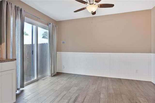 6773 N Askew Cir, Gladstone, MO 64119 - unfurnished room featuring wainscoting, ceiling fan, and light wood-style flooring