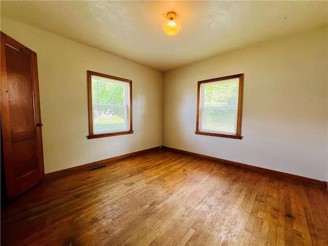 211 W 22nd St, Higginsville, MO 64037 - spare room featuring hardwood / wood-style flooring and baseboards