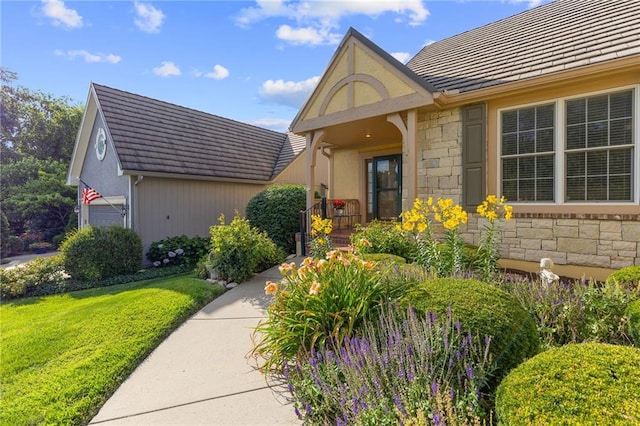 11518 W 143rd Ter, Olathe, KS 66062 - doorway to property featuring stone siding, a lawn, stucco siding, and a tile roof