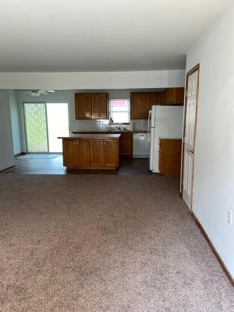 502A 3rd St, Plattsburg, MO 64477 - kitchen with white appliances, open floor plan, dark carpet, and a ceiling fan