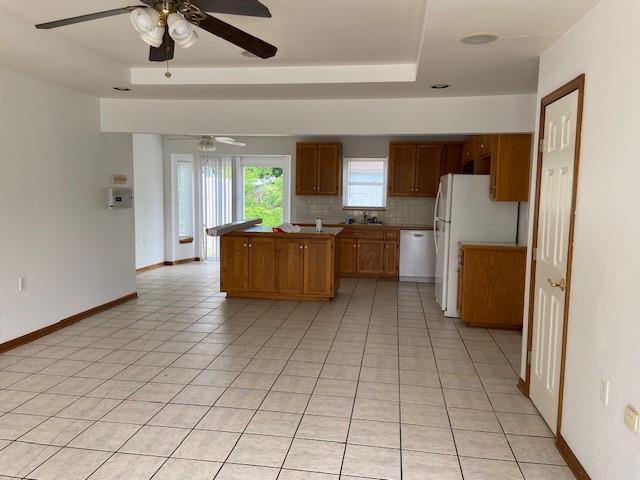 502A 3rd St, Plattsburg, MO 64477 - kitchen with a ceiling fan, dishwashing machine, a tray ceiling, and decorative backsplash