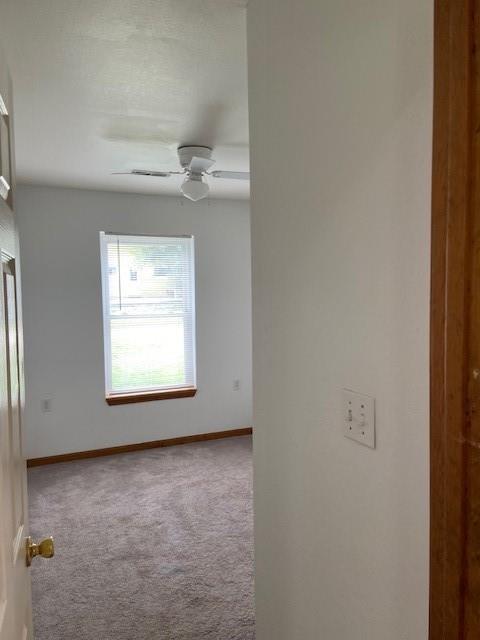 502A 3rd St, Plattsburg, MO 64477 - carpeted spare room featuring baseboards and a ceiling fan
