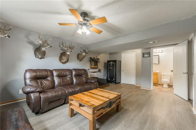 5488 SW Reed Ln, Trimble, MO 64492 - living area featuring light wood-style flooring, a textured ceiling, and ceiling fan