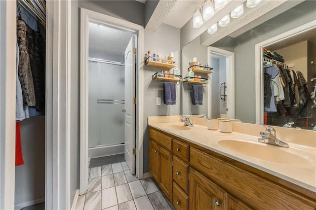 5488 SW Reed Ln, Trimble, MO 64492 - bathroom with marble look tiles, a walk in closet, double vanity, a stall shower, and a textured ceiling