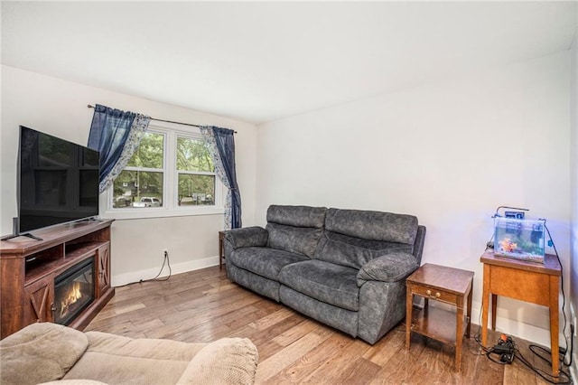 504 W 5th Ct, Peculiar, MO 64078 - living area with wood finished floors, baseboards, and a glass covered fireplace