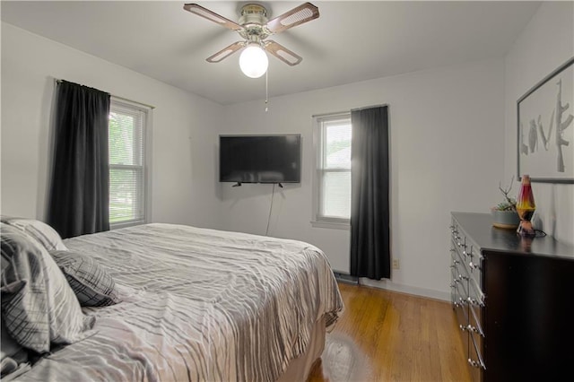 4511 NE 45th St, Kansas City, MO 64117 - bedroom featuring multiple windows, light wood-style flooring, and a ceiling fan