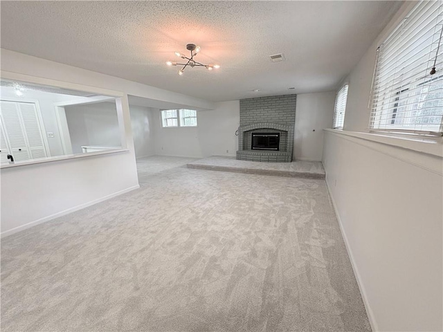 3647 NW Blue Jacket Dr, Lees Summit, MO 64064 - unfurnished living room with carpet, a fireplace, a textured ceiling, and a chandelier