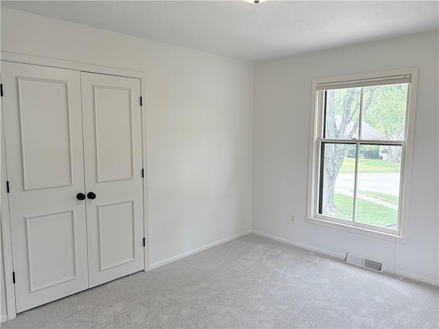 3647 NW Blue Jacket Dr, Lees Summit, MO 64064 - unfurnished bedroom with light colored carpet, multiple windows, and a closet