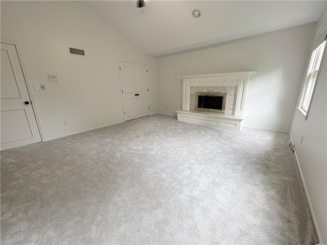 3647 NW Blue Jacket Dr, Lees Summit, MO 64064 - unfurnished living room featuring carpet flooring, vaulted ceiling, and a high end fireplace