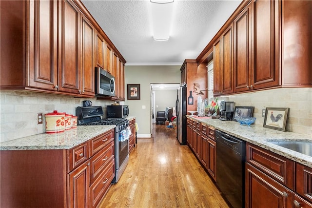 808 N River Blvd, Independence, MO 64050 - kitchen featuring appliances with stainless steel finishes, light wood finished floors, decorative backsplash, light stone countertops, and crown molding