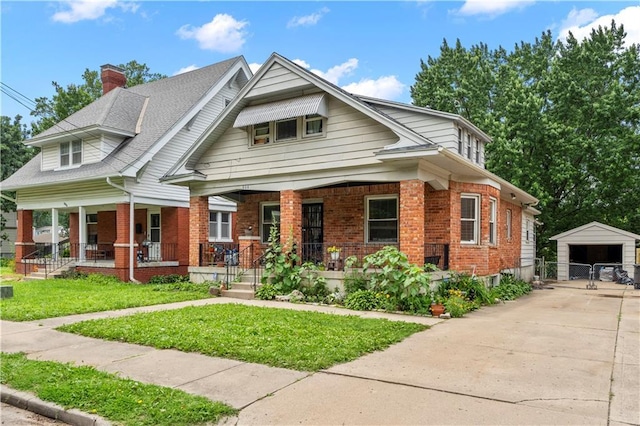 808 N River Blvd, Independence, MO 64050 - view of front facade with covered porch, brick siding, an outbuilding, a front lawn, and a garage
