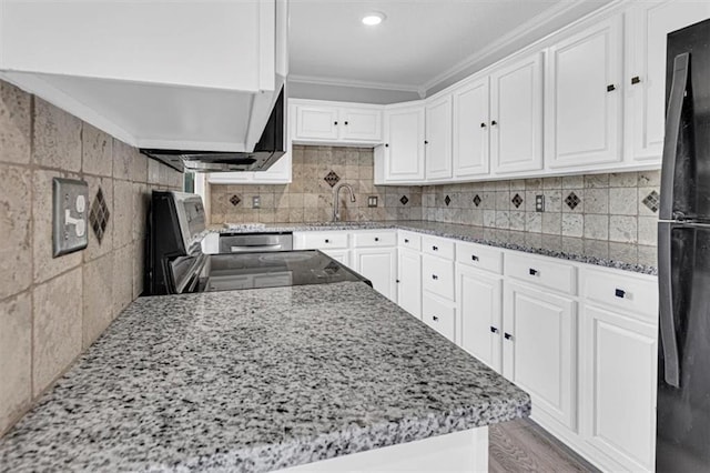 7314 NW 84th Ter, Kansas City, MO 64153 - kitchen with freestanding refrigerator, ornamental molding, light stone countertops, white cabinetry, and stove