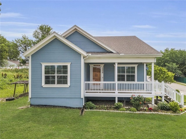 1329 Ann Ave, Kansas City, KS 66102 - view of front of house featuring covered porch, a front yard, and a shingled roof