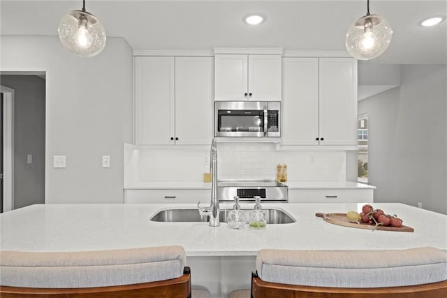8810 SW 9th Ter, Blue Springs, MO 64064 - kitchen featuring stainless steel microwave, decorative backsplash, light stone countertops, decorative light fixtures, and recessed lighting