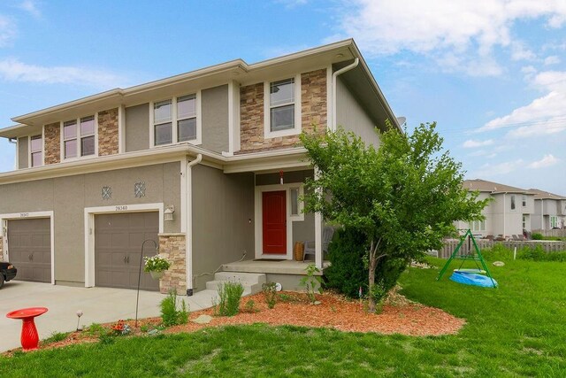 28340 W 164th St, Gardner, KS 66030 - view of front of house with stone siding, an attached garage, a front lawn, and stucco siding