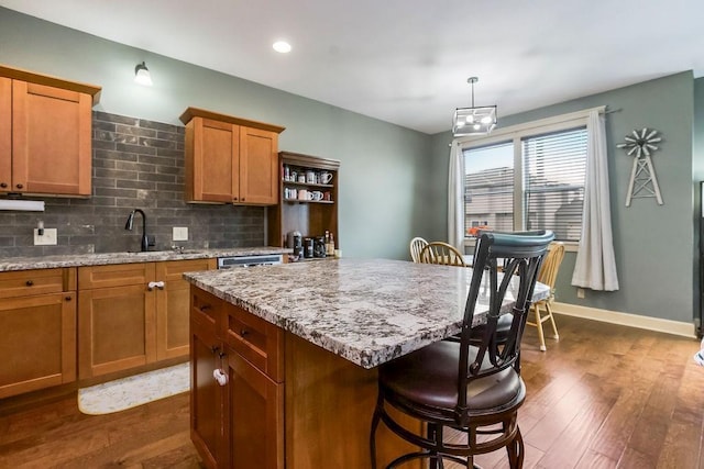 28340 W 164th St, Gardner, KS 66030 - kitchen with a sink, a breakfast bar area, dark wood-style floors, brown cabinets, and recessed lighting