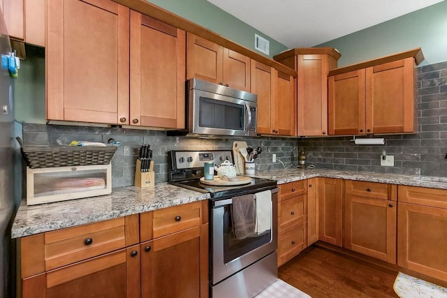 28340 W 164th St, Gardner, KS 66030 - kitchen with appliances with stainless steel finishes, dark wood-style flooring, decorative backsplash, and light stone countertops
