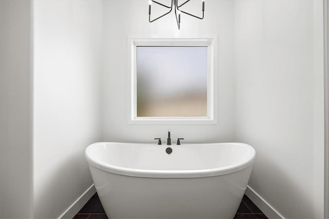 306 SW 17th St, Oak Grove, MO 64075 - bathroom featuring a freestanding bath, tile patterned floors, and a chandelier