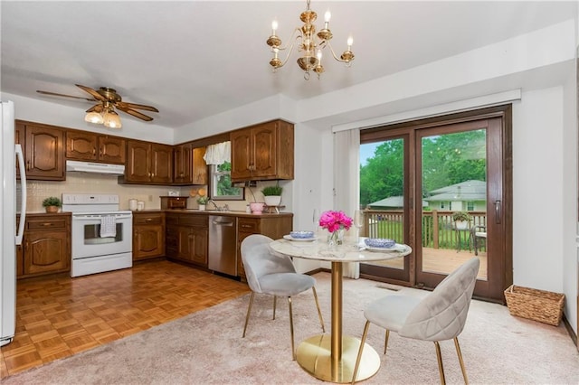13408 Winchester Ave, Grandview, MO 64030 - kitchen with white appliances, under cabinet range hood, plenty of natural light, and a chandelier