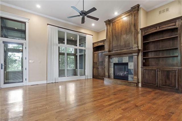 15027 Ash St, Leawood, KS 66224 - unfurnished living room featuring ceiling fan, wood finished floors, a tiled fireplace, crown molding, and recessed lighting