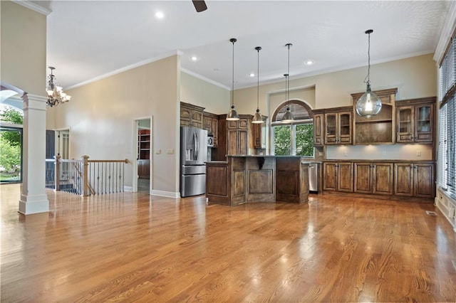 15027 Ash St, Leawood, KS 66224 - kitchen featuring stainless steel appliances, plenty of natural light, ornate columns, light wood finished floors, and recessed lighting