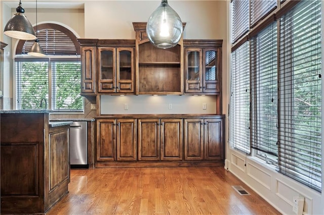 15027 Ash St, Leawood, KS 66224 - kitchen featuring light wood-type flooring, glass insert cabinets, stainless steel dishwasher, decorative light fixtures, and dark brown cabinetry