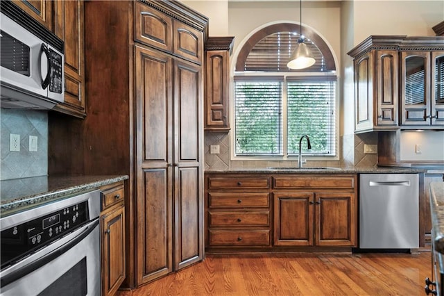 15027 Ash St, Leawood, KS 66224 - kitchen featuring stainless steel appliances, tasteful backsplash, and dark stone countertops