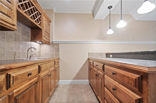 15027 Ash St, Leawood, KS 66224 - kitchen with crown molding, backsplash, hanging light fixtures, light tile patterned floors, and brown cabinetry