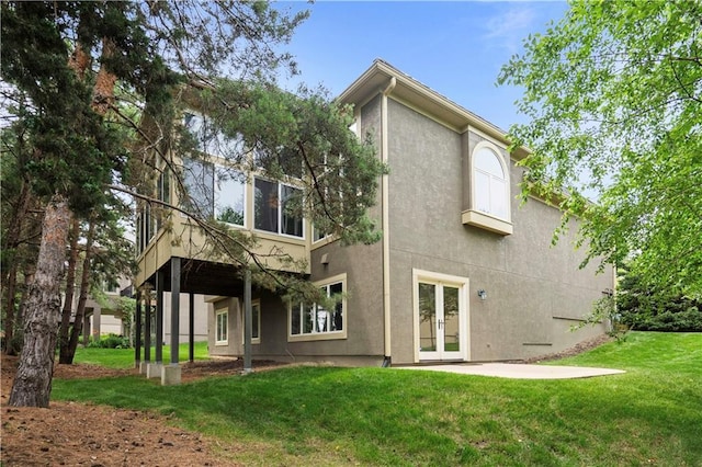 15027 Ash St, Leawood, KS 66224 - rear view of house with french doors, stucco siding, and a lawn